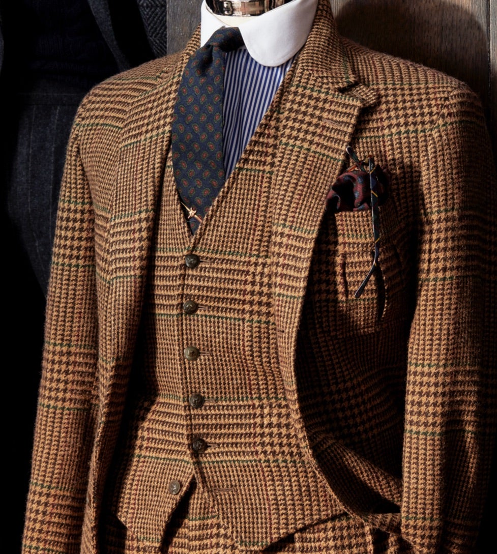 <strong>ELEGANZA AL QUADRATO</strong><br/><span>Un completo a tre pezzi con motivo a quadri principe di Galles oversize in tonalit&agrave; cognac e cammello. Il tessuto, realizzato in Gran Bretagna in esclusiva per la collezione, ha un dettaglio di design in puro stile Polo: un motivo finestrato vinaccia e verde scorre lungo il bordo della quadrettatura, donando all&rsquo;abito l&rsquo;inconfondibile look Ralph Lauren</span>