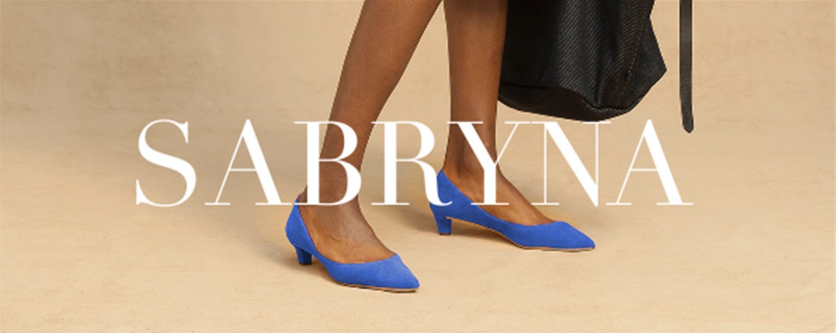 Close-up of woman wearing periwinkle suede pumps
