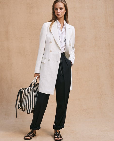 Woman in tan blazer & pants with rolled cuffs